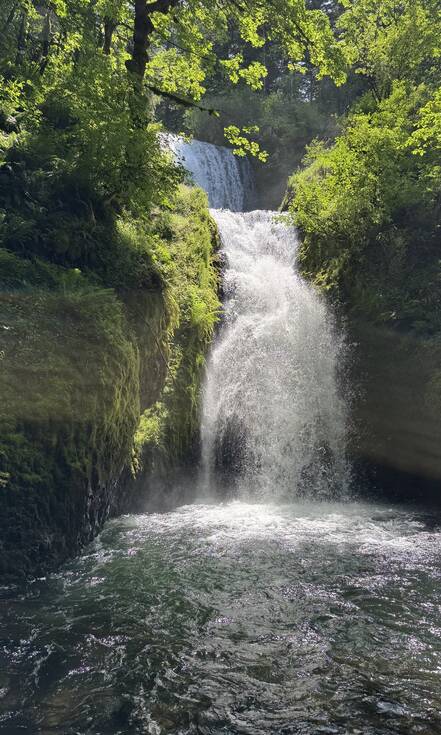 Een hoge smalle waterval die uitkomt in een rivier