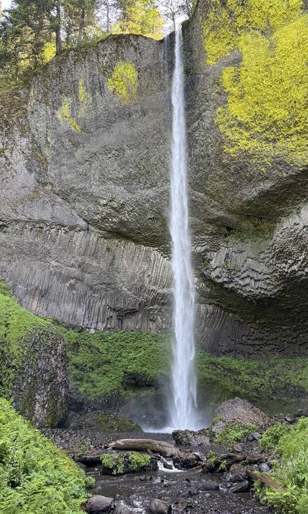 Mirjam bij een hoge waterval in het groen