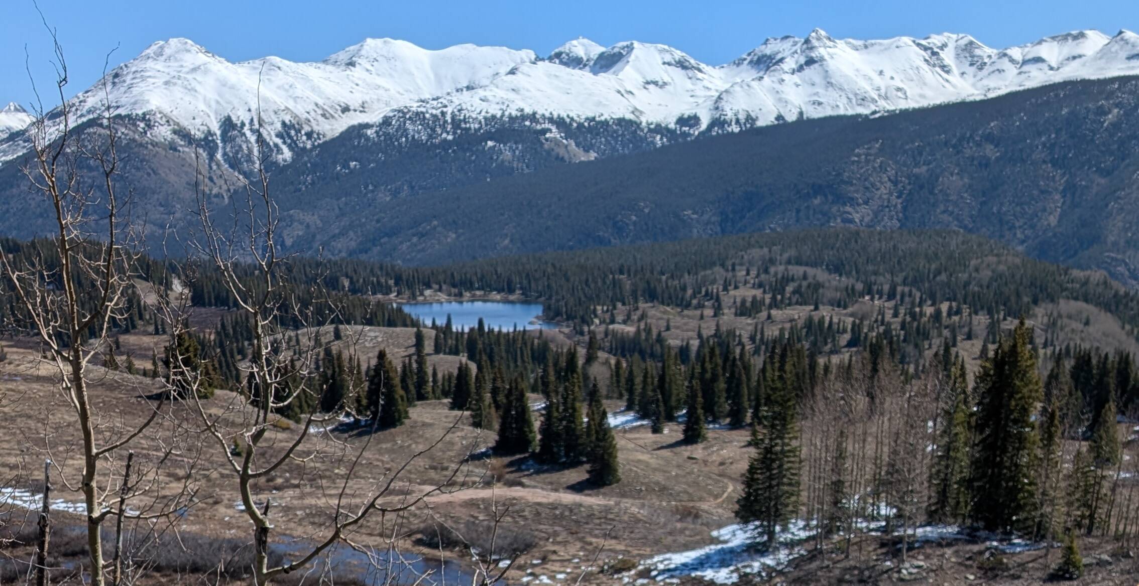 Op de foto zie je besneeuwde bergtoppen langs de Million Dollar Highway in Colorado